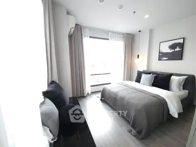 Modern bedroom with large window and stylish decor in a luxury apartment.