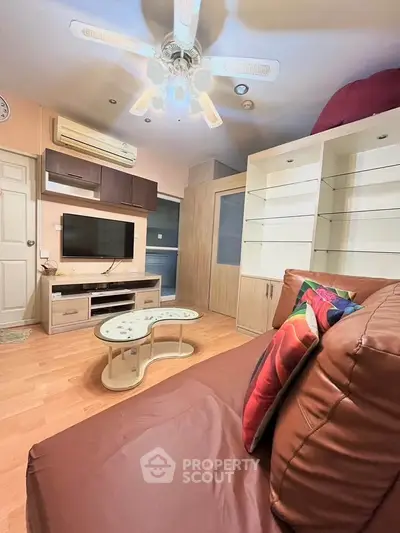 Cozy living room with modern furniture and ceiling fan, perfect for relaxation.