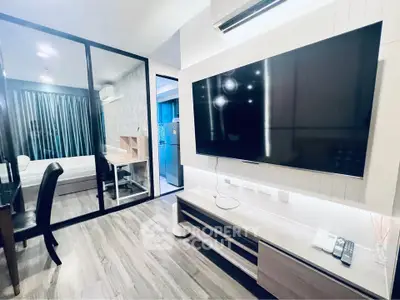 Modern living room with large TV and glass partition to bedroom