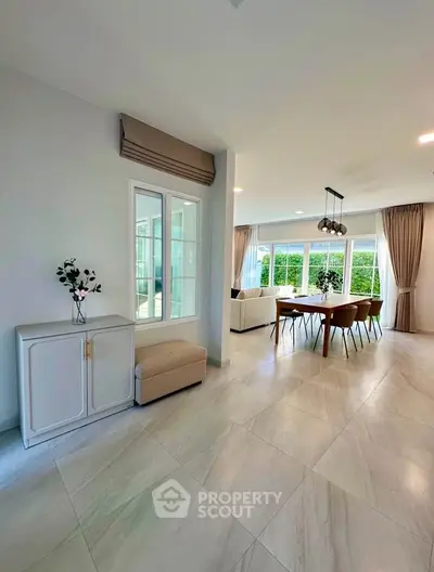 Spacious modern living room with elegant dining area and large windows for natural light.