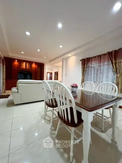Spacious living room with elegant dining area and cozy seating, perfect for family gatherings.