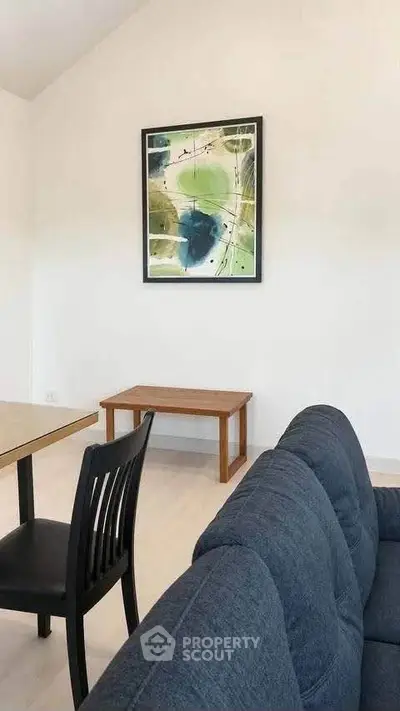Modern living room with stylish furniture and abstract art on the wall, perfect for contemporary living.