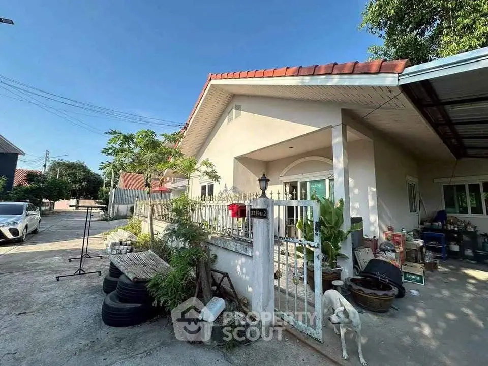 Charming single-story home with gated entrance and lush greenery in a peaceful neighborhood.