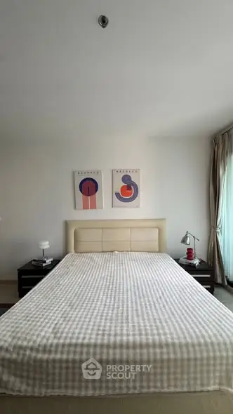 Spacious bedroom with modern decor and large window for natural light.