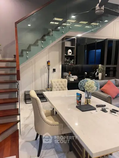 Elegant modern living room with stylish staircase and dining area