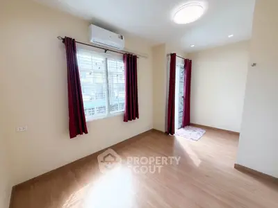 Bright and airy room with wooden flooring and large windows, perfect for a cozy living space.