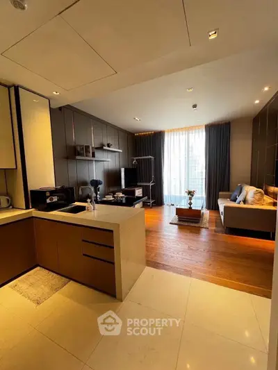 Modern open-layout kitchen and living room with stylish decor and natural light.