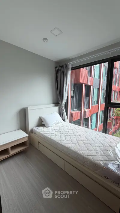 Modern bedroom with large window and minimalist decor in urban apartment