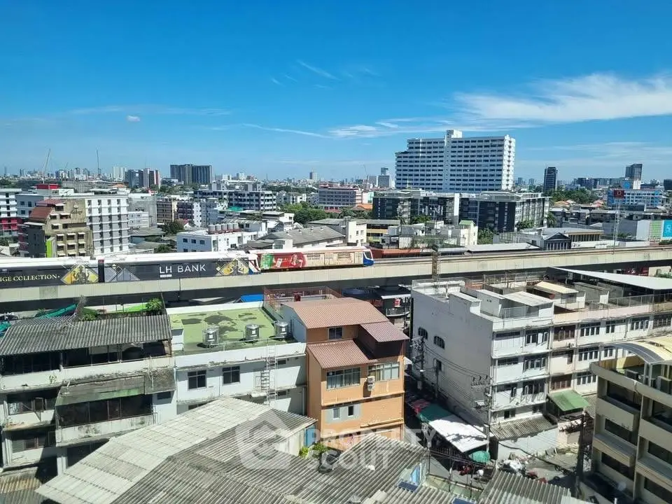 Panoramic cityscape view showcasing diverse urban architecture under a clear blue sky.