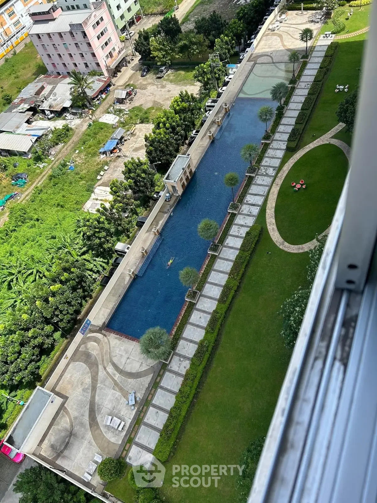Stunning aerial view of luxurious pool and landscaped garden in modern residential complex.