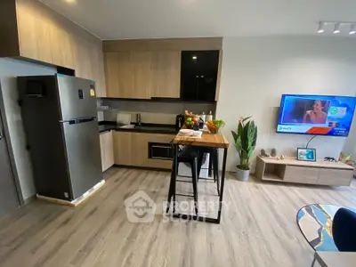 Modern kitchen with sleek appliances and stylish island in open layout apartment.