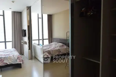 Spacious bedroom with large windows and mirrored closet doors in modern apartment.