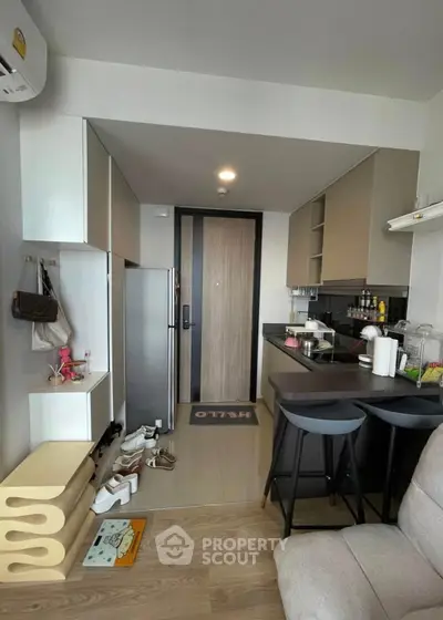 Modern compact kitchen with sleek cabinetry and breakfast bar in stylish apartment.