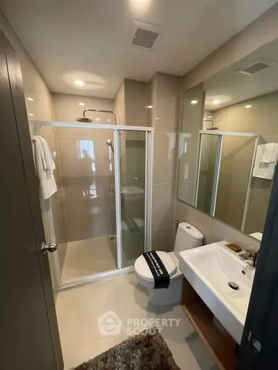 Modern bathroom with glass shower, sleek fixtures, and neutral tones for a contemporary feel.