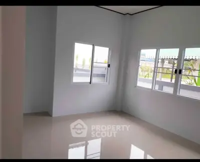 Spacious empty room with large windows and glossy tiled floor, perfect for customization.