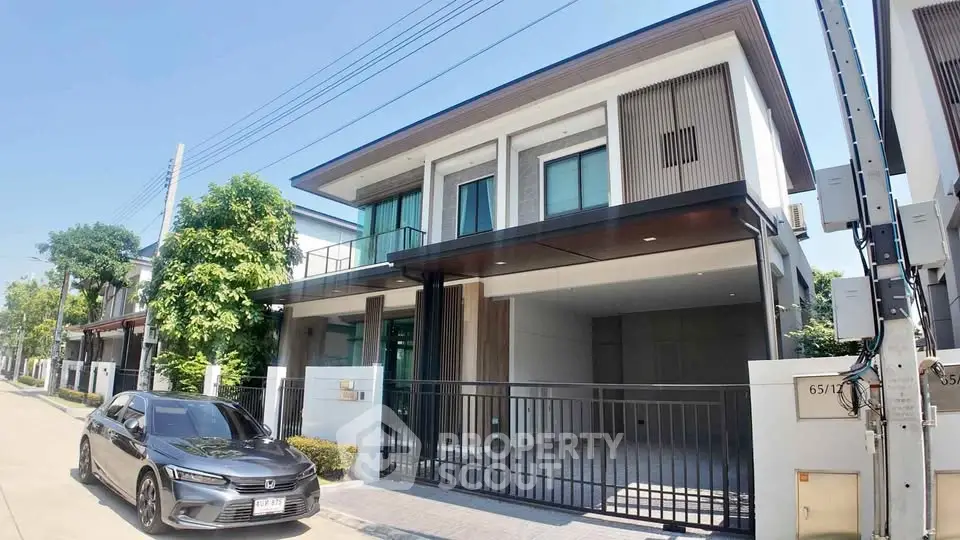 Modern two-story house with sleek design and spacious driveway in a suburban neighborhood.