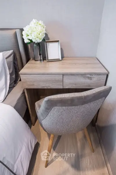 Modern bedroom with stylish wooden desk and elegant chair beside a cozy bed.