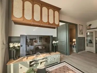 Charming living room with stylish decor and modern TV setup, featuring elegant cabinetry and soft lighting.
