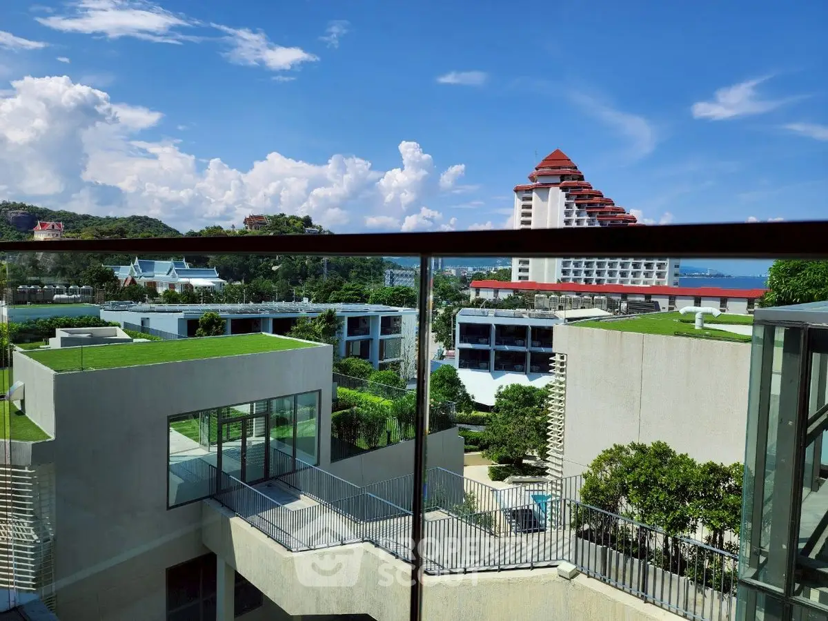 Stunning view from a modern balcony overlooking lush greenery and contemporary architecture.