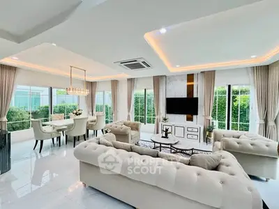 Luxurious open-plan living room with elegant decor and large windows offering garden views.