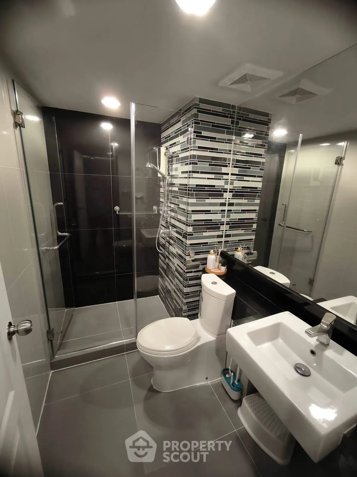 Modern bathroom with sleek design, glass shower enclosure, and stylish tile accents.