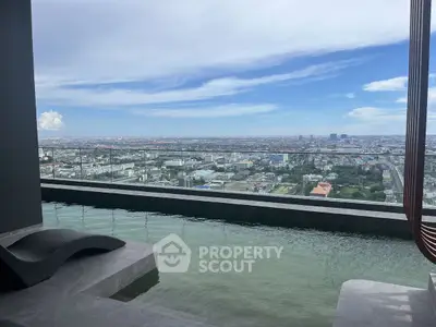 Stunning rooftop pool with panoramic city view under a clear blue sky.