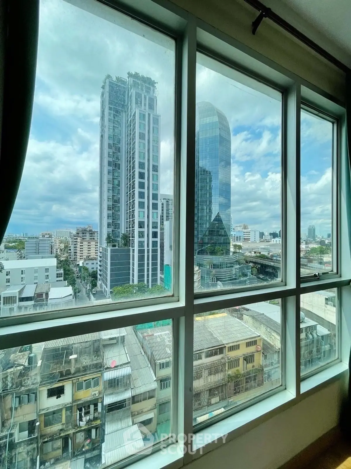 Stunning cityscape view from high-rise apartment window showcasing modern architecture.