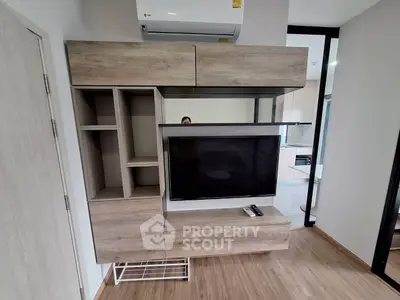 Modern living room with stylish wooden TV cabinet and air conditioning unit.
