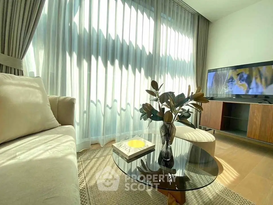 Bright and cozy living room with modern decor and large windows.