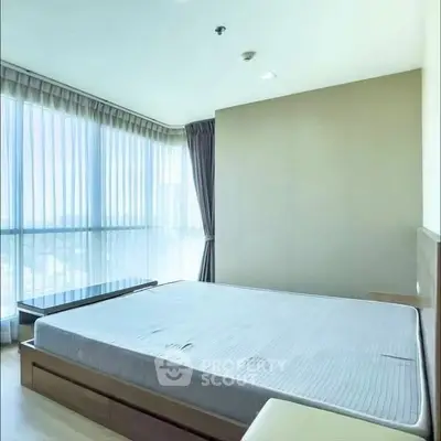 Spacious bedroom with large windows offering panoramic city views.
