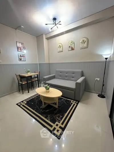 Modern living room with stylish decor, featuring a cozy gray sofa, chic coffee table, and elegant lighting.