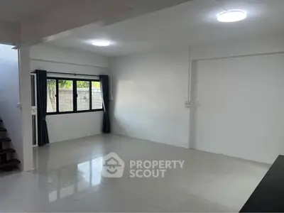 Spacious unfurnished living room with large window and modern lighting