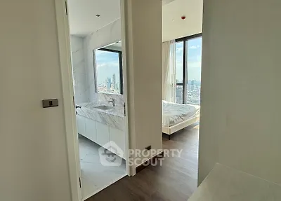 Modern apartment with city view, featuring a sleek bathroom and cozy bedroom.