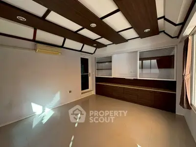 Spacious modern living room with sleek built-in cabinets and stylish ceiling design.