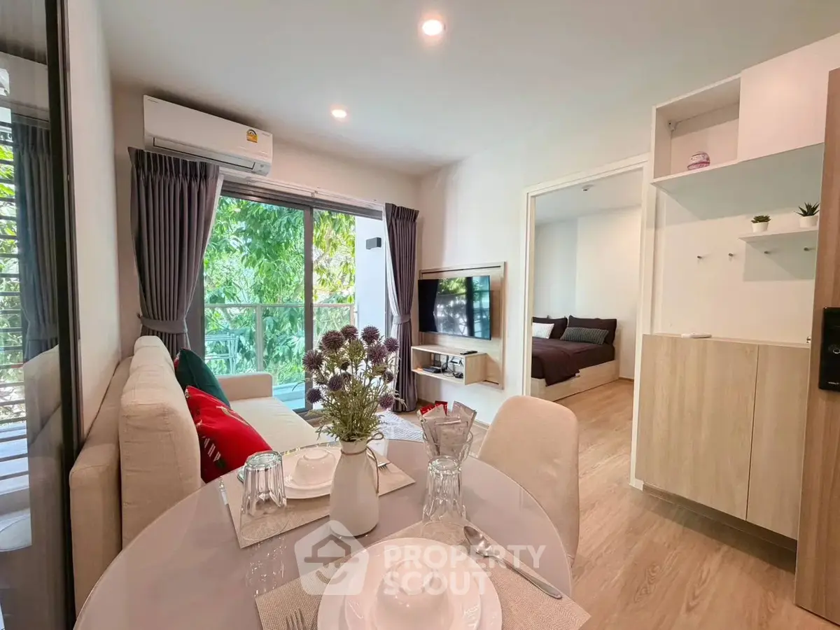 Modern living room with open layout and natural light, featuring cozy dining area and stylish decor.