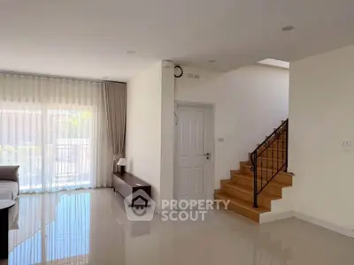 Spacious modern living room with elegant staircase and natural light