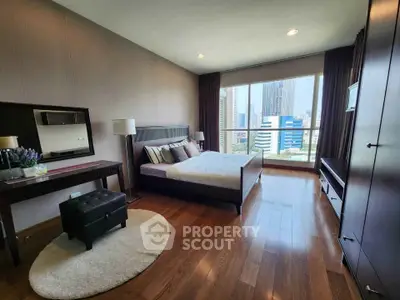 Luxurious bedroom with city view, hardwood floors, and elegant furnishings in a high-rise apartment.