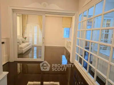 Elegant living room with glossy hardwood floors and large windows for natural light.