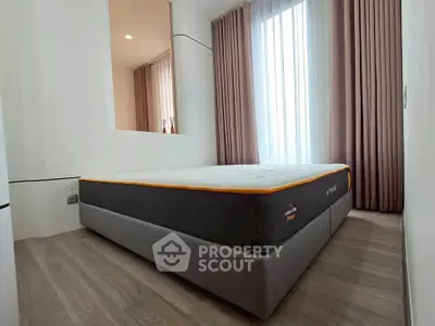 Modern bedroom with stylish bed and floor-to-ceiling curtains in a bright apartment.
