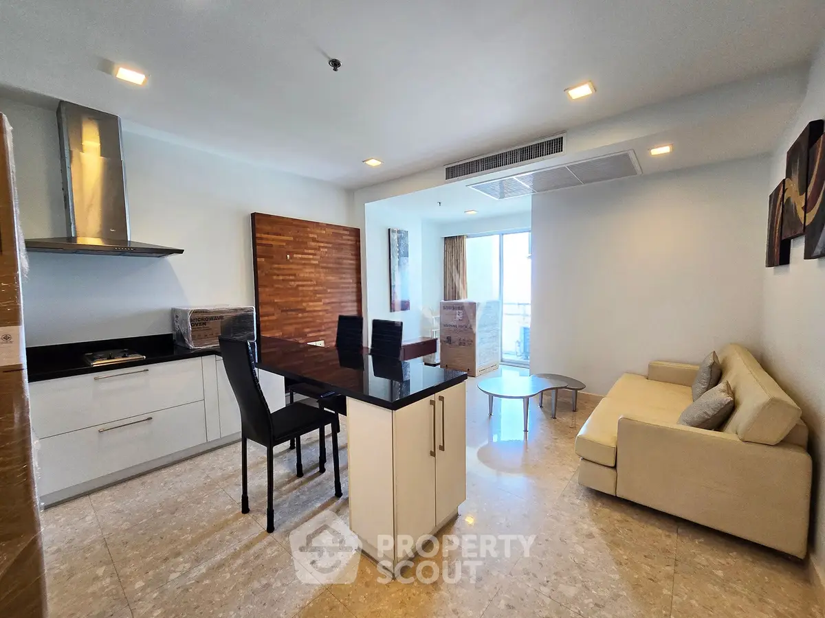 Modern open-layout living room with sleek kitchen and cozy seating area, perfect for urban living.