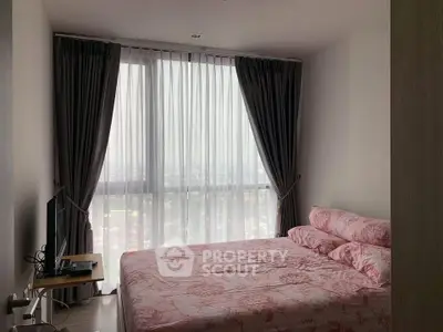 Cozy bedroom with large window and elegant curtains, offering a serene city view.
