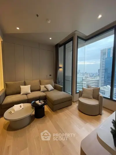 Modern living room with large windows and city view, featuring stylish furniture and cozy ambiance.