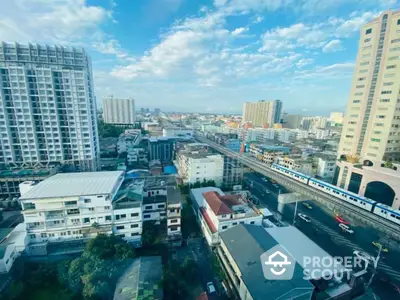 Stunning cityscape view from high-rise apartment with clear blue sky and urban skyline.