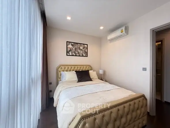 Cozy bedroom with elegant decor and natural light in modern apartment.