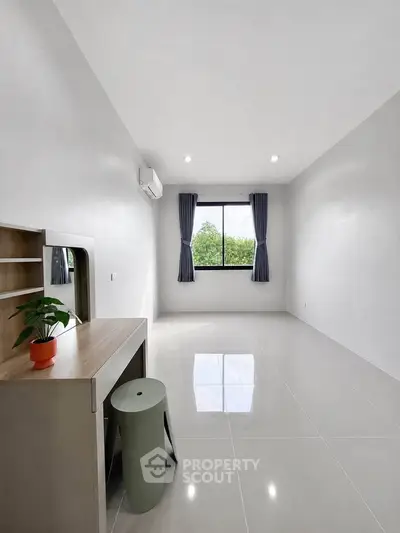 Spacious minimalist room with large window and modern furniture, perfect for a serene living space.
