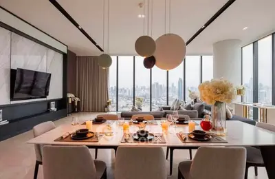 Luxurious open-plan living and dining area with panoramic city views and modern decor.