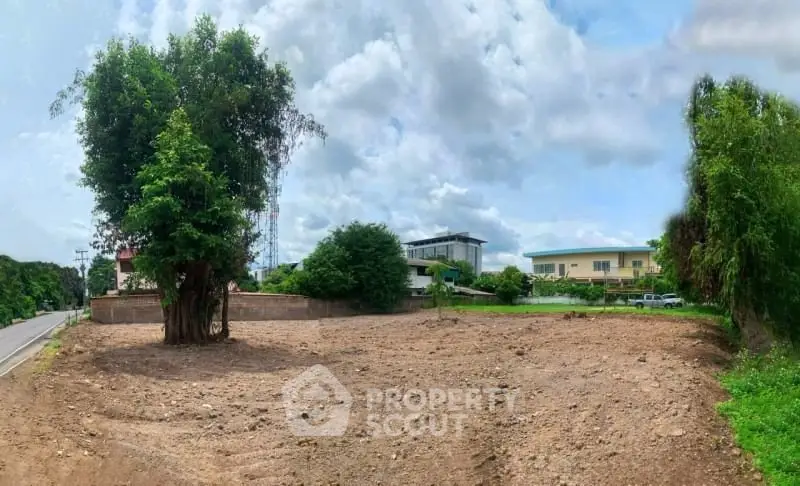 Spacious vacant land with lush greenery and clear skies, ideal for development opportunities.