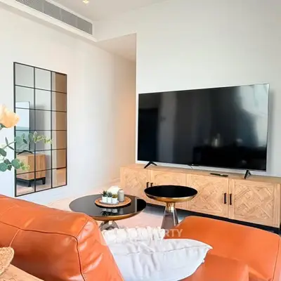 Modern living room with large TV, stylish furniture, and elegant decor