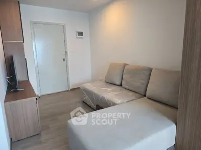 Modern living room with cozy sectional sofa and sleek wooden TV stand, perfect for relaxation.
