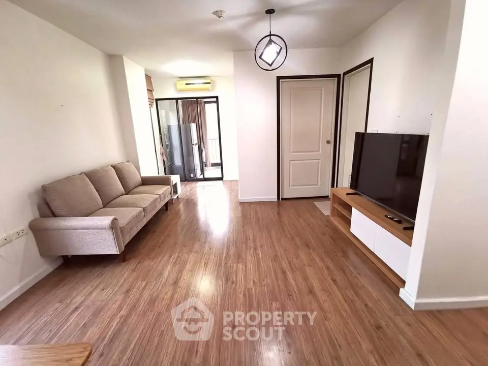 Spacious living room with modern decor and wooden flooring in a stylish apartment.